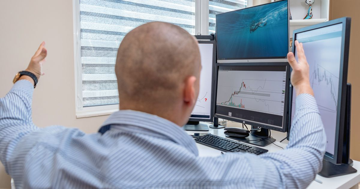 Stock trader analyzing multiple computer screens