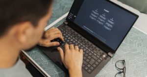 Man wearing glasses using an AI chatbot on a laptop