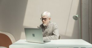 Business professional working on a laptop at a table in a modern office