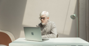 Business professional working on a laptop at a table in a modern office