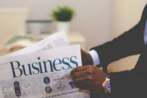 Person reading business newspaper in office