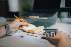 Planning a marketing budget with a calculator and notebook
